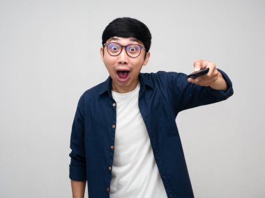 Asyalı adam uzaktan kumandalı televizyon karşısında heyecanlanıyor.