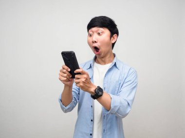 Asyalı adam mavi gömlekli, akıllı telefon kullanıyor ve kontrol ediyor.