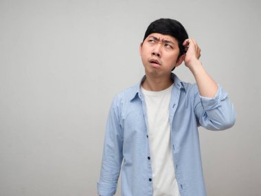 Mavi gömlekli adamın kafası karışmış ve fotokopi odasına bakarken kafası karışmış.