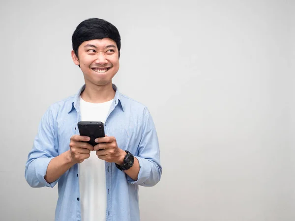 Positive man using mobile phone and smiling thinking about food feels hungry isolated