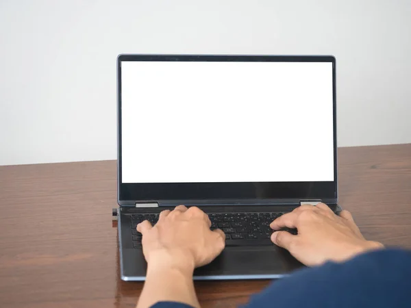 Man hands using keyboard of laptop mockup white screen on the table