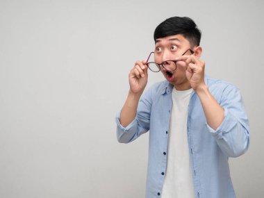 Genç Asyalı mavi gömlekli adam şok olmuş hissediyor. Gözlüklerini çıkar ve yalnız görün.