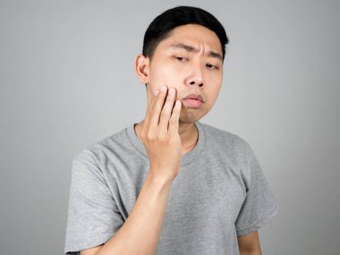 Asyalı genç bir adam sivilcelerini kontrol ederken kendini yalnız hissediyor.