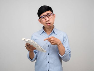 Müdür gözlük takıyor ve günlüğünü karıştırıyor.