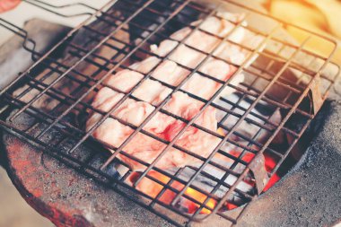 Izgara domuz ızgarası ya da pişirmek için kızarmış domuz bifteği. Tayland yemeği, sokak yemeği. Ocakta domuz ızgarası ya da markette Tayland usulü kızarmış domuz eti..