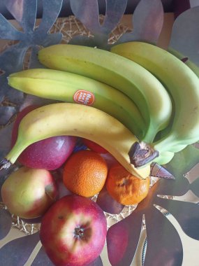 Bir meyve kasesi: muz, elma, mandalina