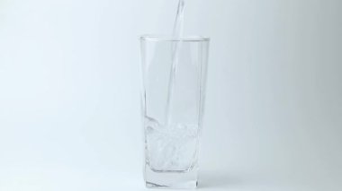 Tatlı su içeceğini gri arka plandaki bardağa döküyorum. Dökülen su