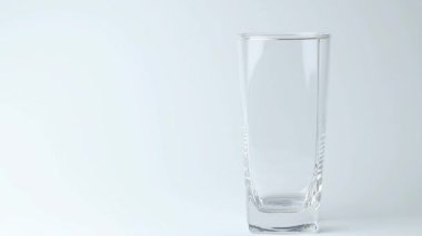Tatlı su içeceğini gri arka plandaki bardağa döküyorum. Dökülen su