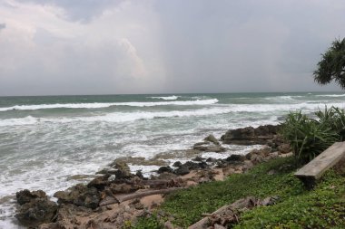 Sahilde güzel beyaz su kabarcıkları. Dalgaların dalgalandığı bir sahil. Kayalıkların oluşturduğu deniz dalgaları ve kabarcıklar.
