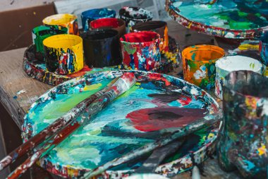 Ressam resimlerini parlak renklerle çizer.