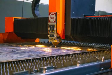 Fabrikadaki lazer makinesi metalle çalışıyor.