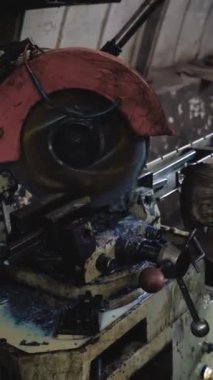 Dikey video, fabrika işçisi metali kesiyor. Kıvılcımlar. Üretim