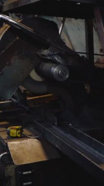 Dikey video, fabrika işçisi metali kesiyor. Kıvılcımlar. Üretim