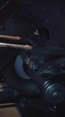 Dikey video, fabrika işçisi metali kesiyor. Kıvılcımlar. Üretim