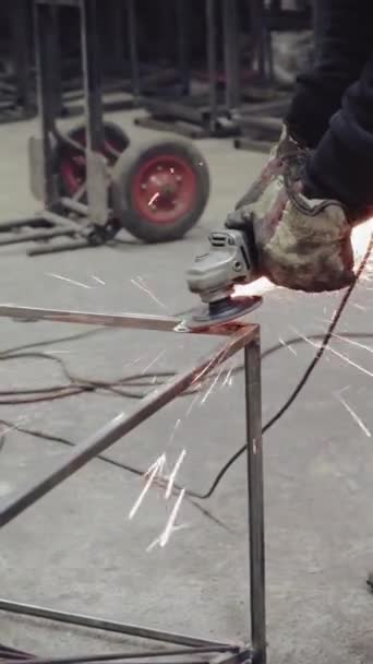 垂直ビデオ 工場の従業員は金属加工に取り組んでいます 火花が飛ぶ — ストック動画