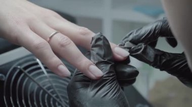 The process of manicure in a beauty salon close-up. Cuticle removal