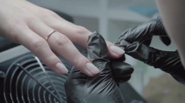 The process of manicure in a beauty salon close-up. Cuticle removal