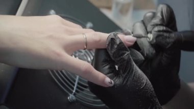 The process of manicure in a beauty salon close-up. Removal of the coating by the device