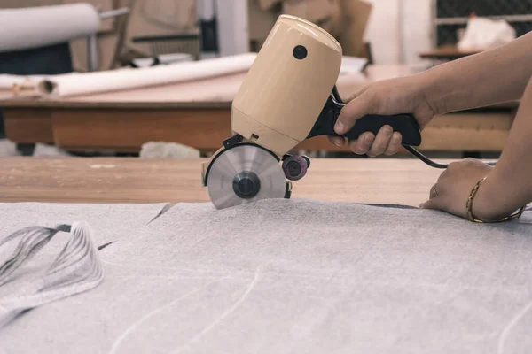 The cutter cuts the fabric with a disc cutting knife in the sewing workshop