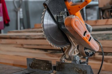 Sawing machine for wood in the workshop for the production of furniture. Woodworking circular saw and wooden bar for cutting.