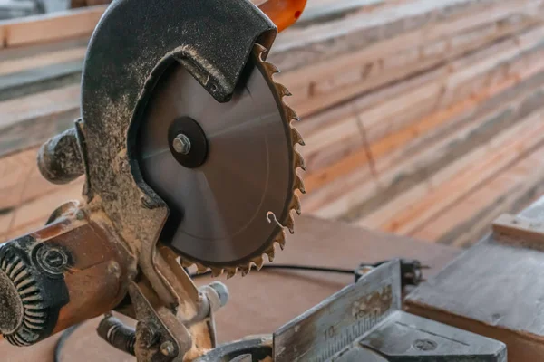 Sawing machine for wood in the workshop for the production of furniture. Woodworking circular saw and wooden bar for cutting.