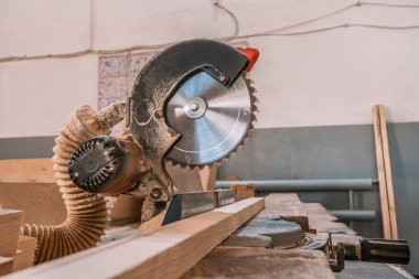 Sawing machine for wood in the workshop for the production of furniture. Woodworking circular saw and wooden bar for cutting.