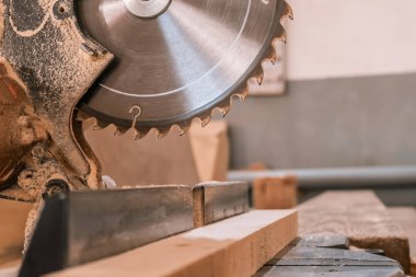 Sawing machine for wood in the workshop for the production of furniture. Woodworking circular saw and wooden bar for cutting.