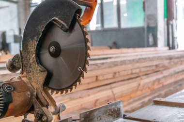 Sawing machine for wood in the workshop for the production of furniture. Woodworking circular saw and wooden bar for cutting.