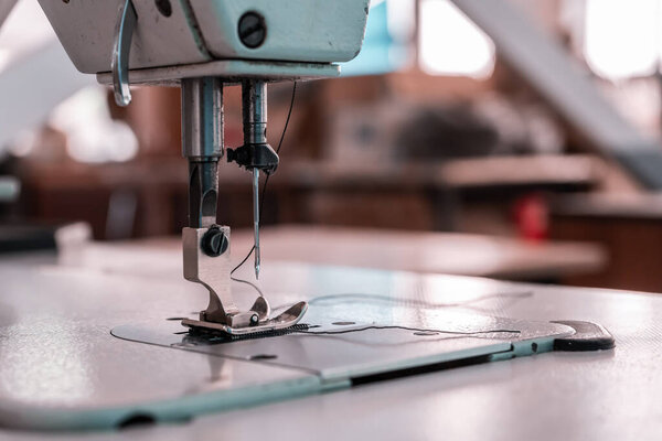 Иголки швейных машин крупным планом в цехе