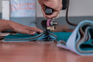 The cutter cuts the fabric with a disc knife in a sewing workshop