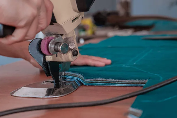 The cutter cuts the fabric with a disc knife in a sewing workshop