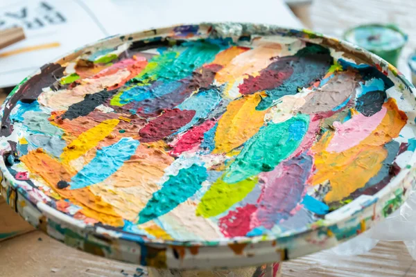 Spots of bright paint in the palette in the art workshop