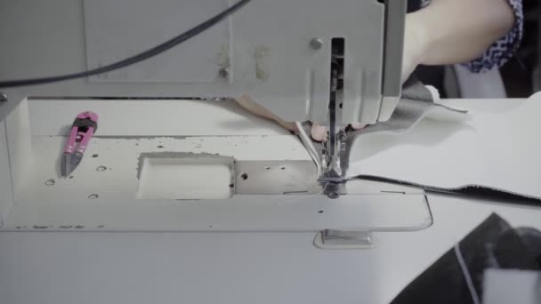 车间的女裁缝在缝纫机上缝制一种用白色真皮做的产品 — 图库视频影像