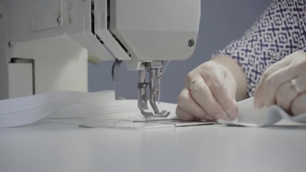 车间的女裁缝在缝纫机上缝制一种用白色真皮做的产品 — 图库视频影像
