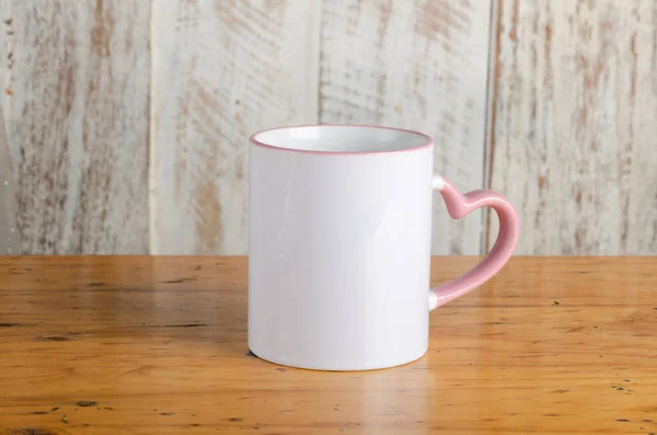 Boş beyaz ve kolej kupası fotoğrafı. Kırsal ahşap arka planda pembe.