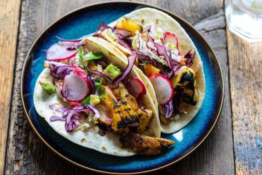 Baharatlı tavuklu taco, ızgara ananas ve lahana salatası.