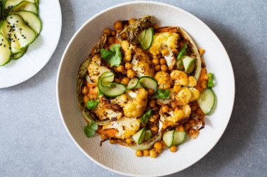 Kızarmış karnabahar ve salatalık turşusu ve kırmızı biber soslu nohut.