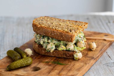 Ev yapımı ekmek üzerine avokado, dereotu, soğan ve hardal soslu kremalı nohut salatası.