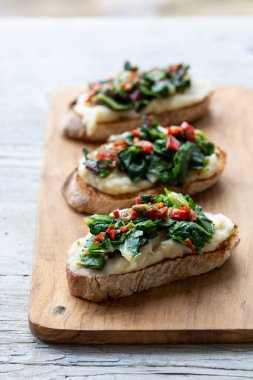 Beyaz fasulyeli crostini ve patates püresi ve İsviçre pazısı.