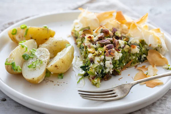 Vegetarian filo pastry pie with green peas, feta and pistachio nuts