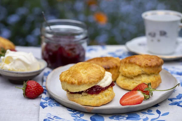 Taze pişmiş ev yapımı çilek reçeli ve pıhtılaşmış kremalı çörekler.