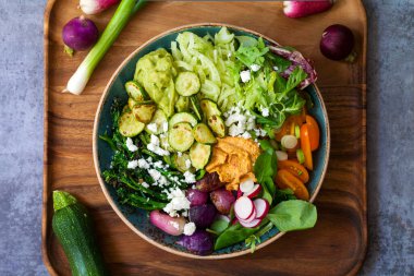 Karışık rosto, çiğ sebze, guacamole, humus ve miso soslu Buda kasesi.