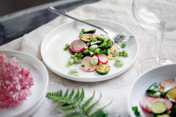 Fresh garden salad with broad beans, green peas, radishes and courgette