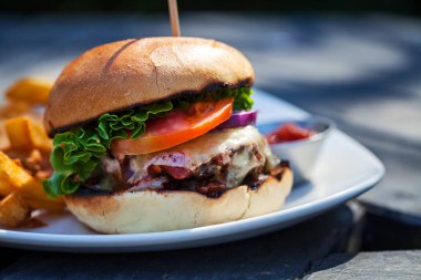 Erimiş peynirli sığır burger ve patates kızartması.
