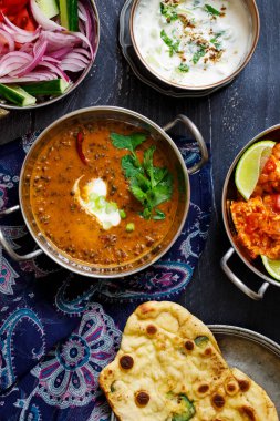 Hint yemeği siyah mercimek dallı, baharatlı patates, pilav, naan ekmeği ve raita.