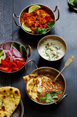 Hint yemeği siyah mercimek dallı, baharatlı patates, pilav, naan ekmeği ve raita.