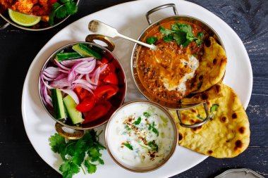 Hint yemeği siyah mercimek dallı, salata, naan ekmeği ve raita