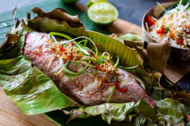 Muz yaprağı ve papaya salatasında pişirilmiş kırmızı levrek. 