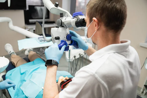 Dentista con microscopio dental — Foto de Stock