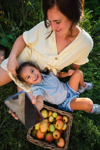 Caucasian mother and her Asian daughter take a selfie — Stok fotoğraf